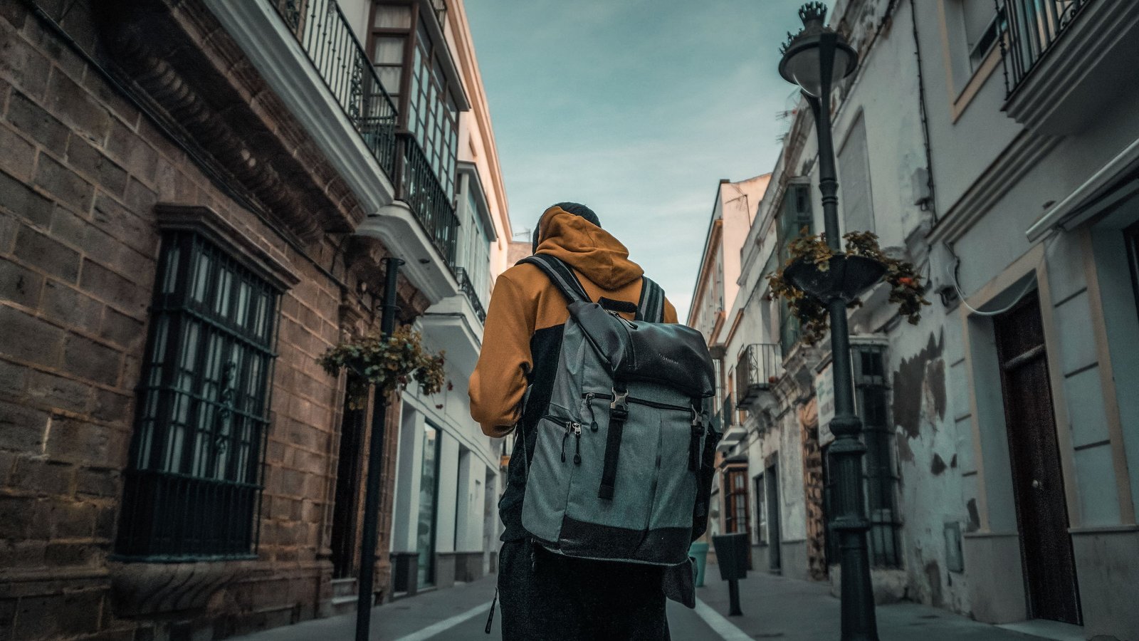 Daniel Ros de espaldas con la mochila, caminando por una calle de Cádiz